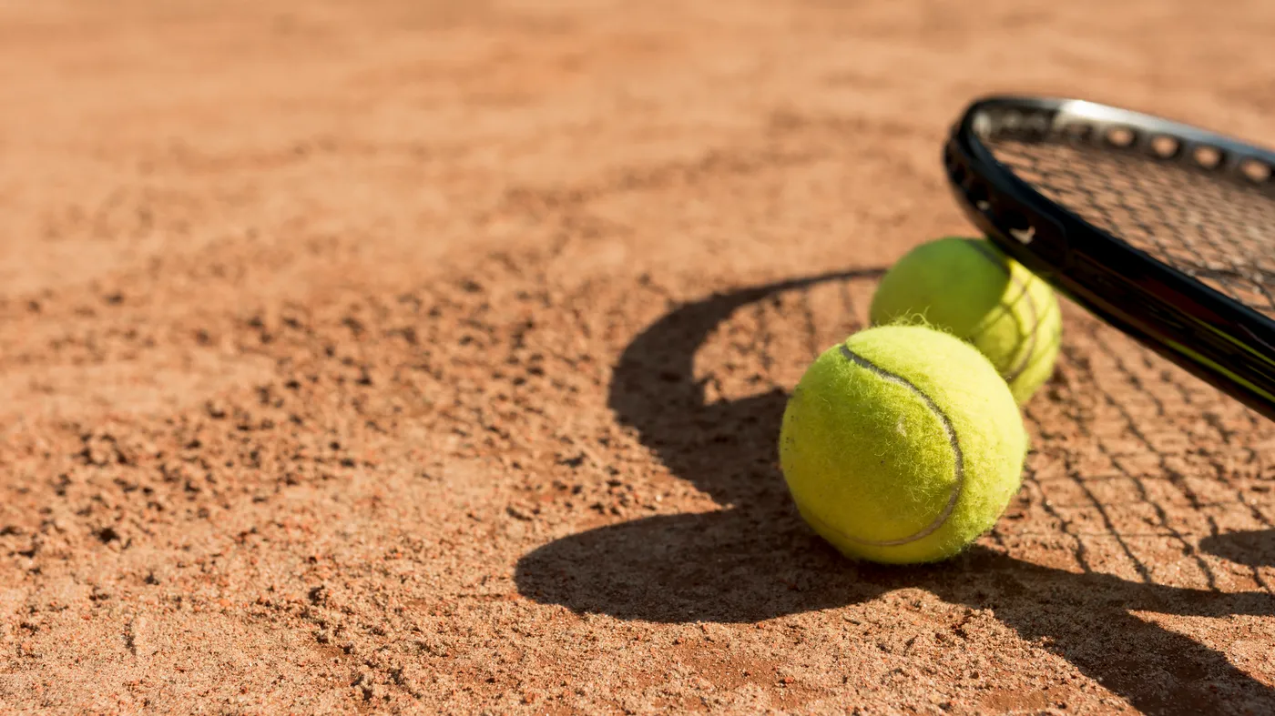 Tennis Balls Black Racket Tennis balls and racket on a clay court